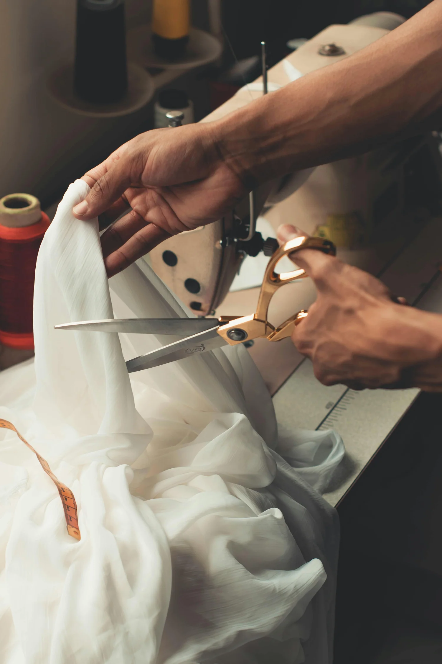 Tailor cutting fabric at a sewing machine